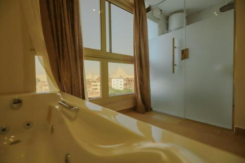 开罗King Khafren View INN的一间带大浴缸和窗户的浴室