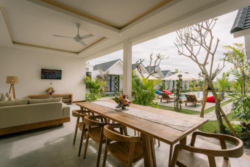 坎古Sari Uma Canggu By Hospitality Bali的客厅配有木桌和椅子
