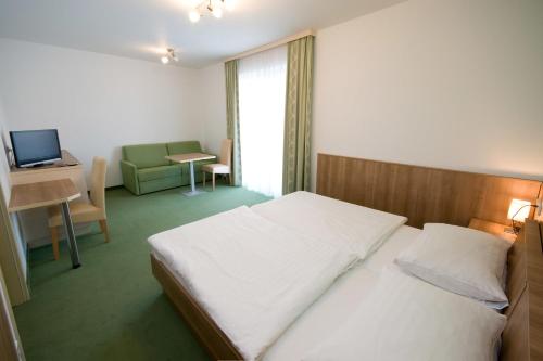 劳申瓦斯鲍尔酒店的一间卧室配有一张床、一张书桌和一台电视