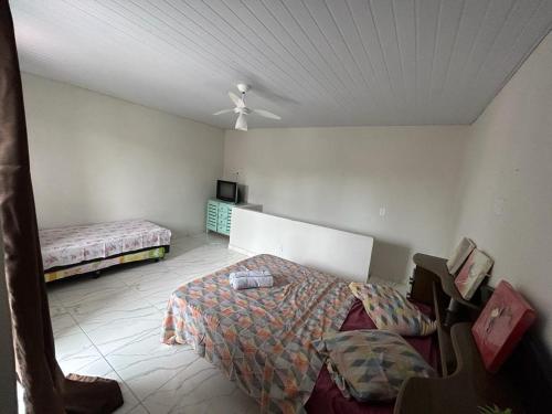 大伊瓜巴Casa iguaba com área de lazer的一间卧室配有一张床和吊扇