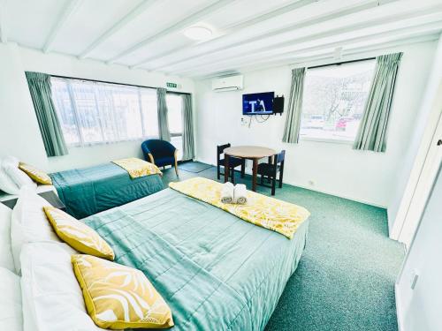 基督城哥特式高地汽车旅馆的一间卧室配有两张床和一张桌子
