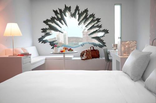 略夫雷加特河畔奥斯皮塔莱特Renaissance Barcelona Fira Hotel的卧室配有一张白色的大床和一张桌子