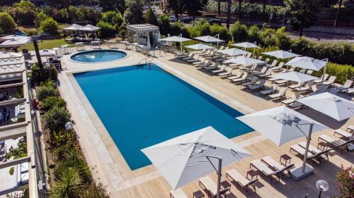 罗马罗马欧洲帕克德伊美第奇假日酒店的享有带椅子和遮阳伞的游泳池的上方景致