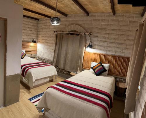 乌尤尼HOTEL CASONA DE SAL的一间卧室,配有两张床