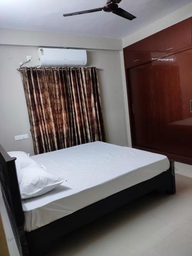 维沙卡帕特南Rahul guest house的一间卧室配有一张带吊扇和窗户的床。