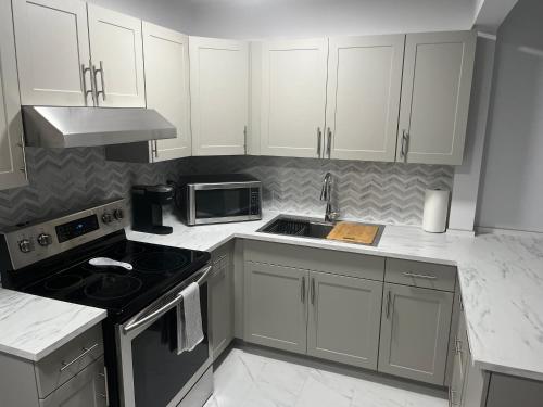 渥太华Casa LACK - Tranquila Suites 3的厨房配有白色橱柜和炉灶烤箱。