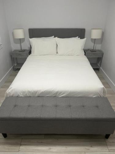 渥太华Casa LACK - Tranquila Suites 3的一张带白色床单和两盏灯的大床