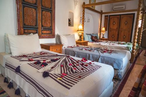 马拉喀什Riad Sérénis的一间卧室配有两张床,装饰有装饰