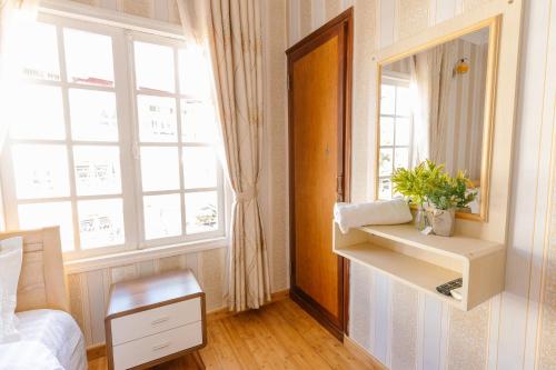 阿普春安BACH TÙNG Garden Village的一间卧室配有镜子、一张床和一个窗户