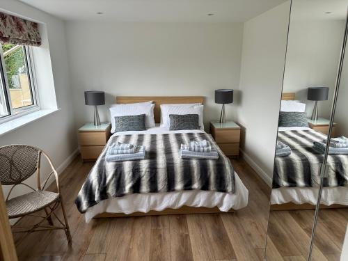 格拉斯顿伯里Glastonbury Vista的一间卧室配有两张床和镜子