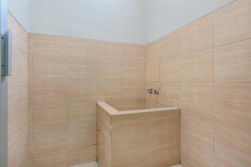 TuntangOYO Life 90159 Puri Asoka Guest House的一间带木墙和浴缸的浴室