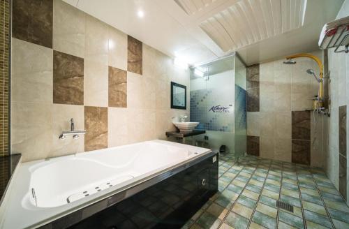 蔚山Hotel Kobos的带浴缸和盥洗盆的大浴室