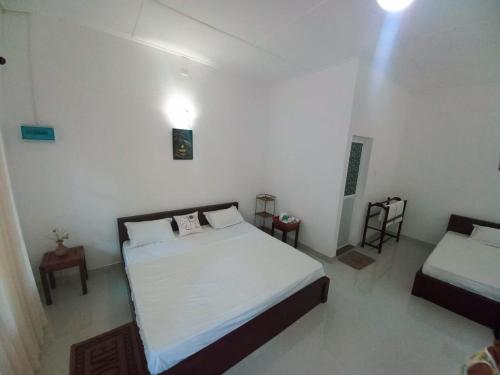阿努拉德普勒S & D Resort的一间白色客房内带两张床的卧室