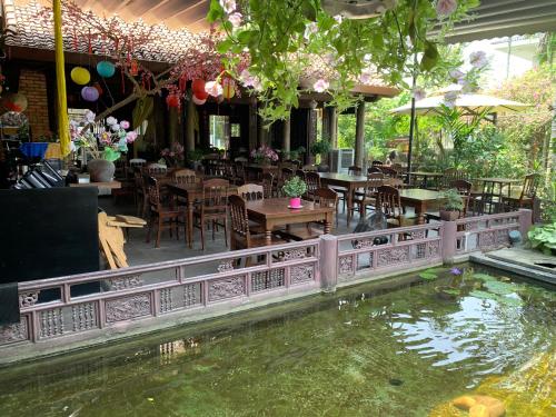 顺化Mandarin Homestay Hue的一个带桌椅的餐厅内的锦 ⁇ 池