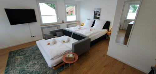 波鸿CityChalet-neu renoviert-Küche-ruhig-Parkplatz的一间卧室配有一张床、一张沙发和一面镜子