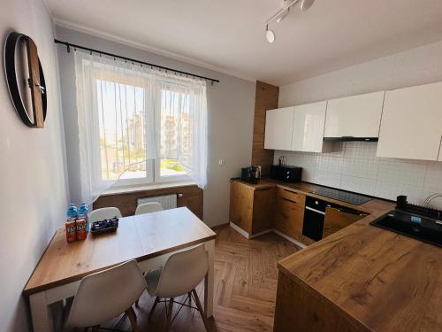 什切齐内克Apartament Neustettin-Polna Szczecinek的厨房配有桌椅和窗户。