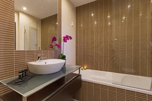阿尔布费拉市中心D阁楼公寓的浴室配有白色水槽和浴缸。
