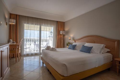 代森扎诺-德尔加达皇宫酒店的一间带大床的卧室和一个阳台