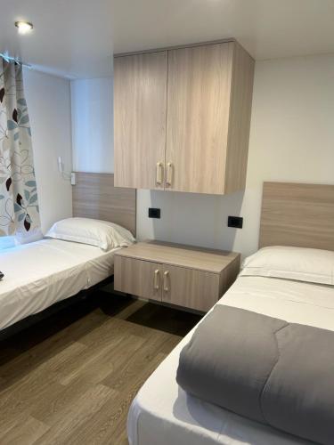 托斯科拉诺-马德尔诺Villaggio Turistico Maderno的一间卧室设有两张床和橱柜