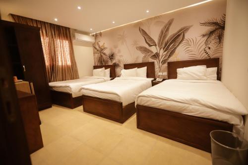 开罗King Khafren View INN的配有白色床单的酒店客房内的两张床