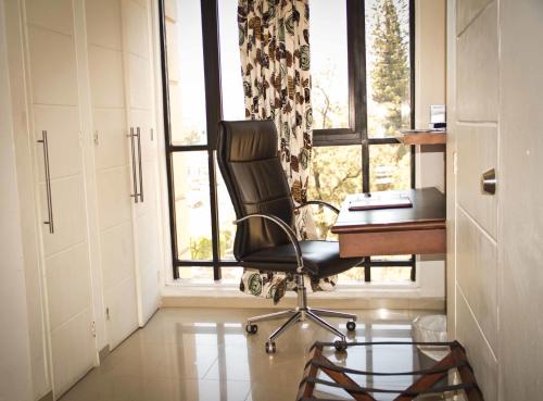 特古西加尔巴Minister Business Hotel的一个带椅子和书桌的办公室和一个窗口