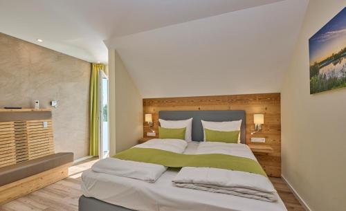 KirchrothBachhof Resort Apartments的一间卧室配有一张带绿色和白色枕头的大床