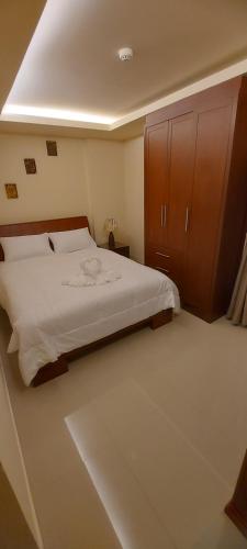 芭堤雅市中心City Garden Pattaya - 2br Suite, 76sqm的一间卧室配有一张大床和一个木制橱柜