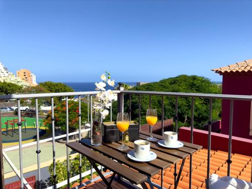 塔瓦伊瓦Las Vistas-Rincón acogedor con vistas al mar的阳台上的桌子和两杯葡萄酒
