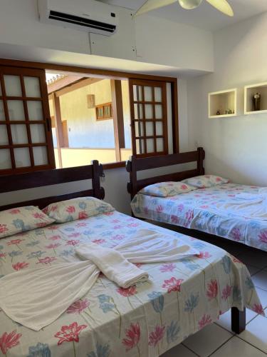 普拉亚多Condomínio Solar dos Peixes的一间卧室设有两张床和窗户。