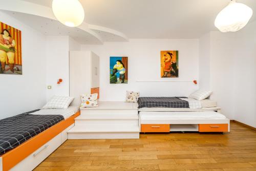 贝尔格莱德Apartment Botero的墙上挂有绘画的客房内的两张床
