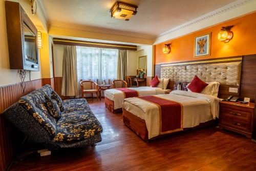 大吉岭小西藏酒店的酒店客房,配有两张床和椅子
