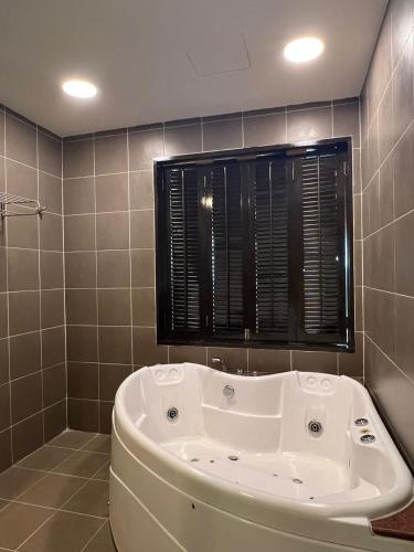 万津Studio 7 Gold Coast Morib Resort的带浴缸的浴室和窗户
