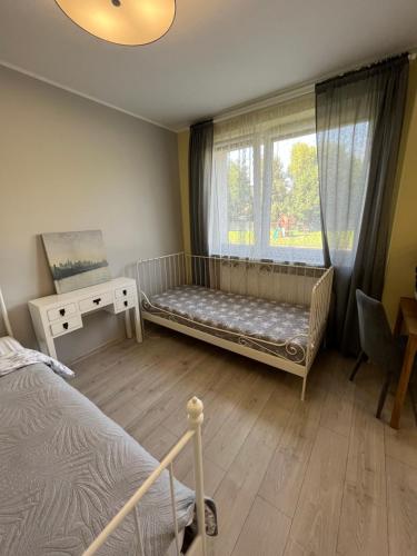 克罗托申Apartament COMFORT Centrum的一间卧室配有一张床,窗户配有婴儿床