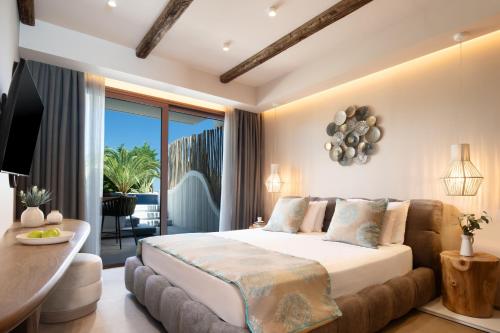 克里斯阿穆迪亚亚历山大黄金精品酒店（仅限成人）的一间带大床的卧室和一个阳台