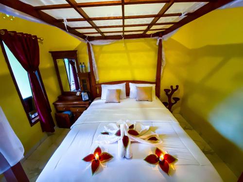 新加拉惹Ananda Homestay Lemukih的一间卧室,床上放着鲜花