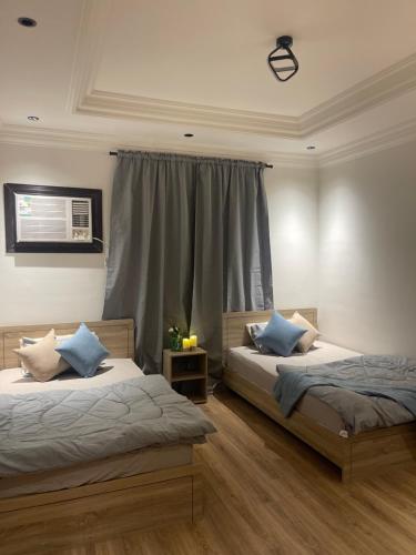 麦地那Taibah Apartment的一间卧室设有两张床和窗户。