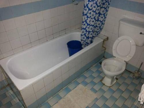 IyibaRoom in Lodge - Garentiti Apartment - Silver Room的浴室配有卫生间、浴缸和卫生间。