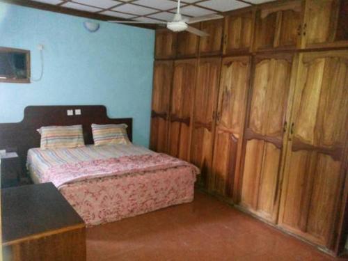 IyibaRoom in Lodge - Garentiti Apartment - Silver Room的一间卧室配有一张床和木制橱柜