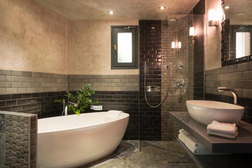 Callas莱斯格吉斯佩那福特酒店的浴室配有白色浴缸和水槽