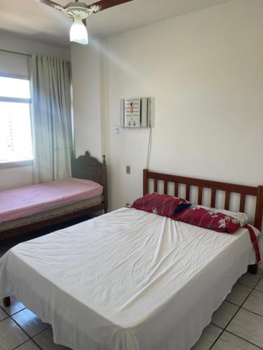 瓜拉派瑞Apartamento Guarapari pé na areia com Wi-Fi e Garagem的卧室设有一张白色大床和一扇窗户。