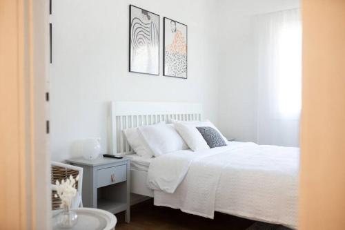 赖阿南纳lovely apartment in Ra'anana的白色的卧室配有白色的床和一张桌子