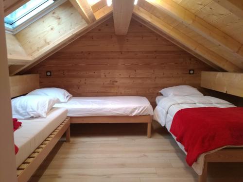瓦卢瓦尔Chalet des Lys - tout confort - 12 personnes的阁楼间设有两张床铺和木墙