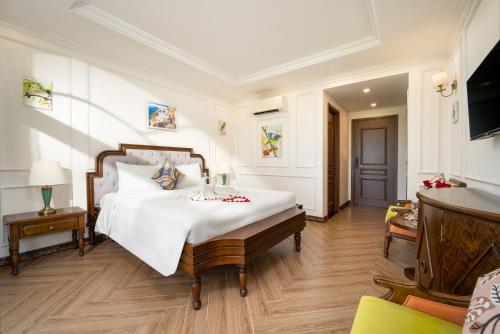 会安Maison Fleur Luxury Hoi An的卧室配有一张白色的大床和一张桌子