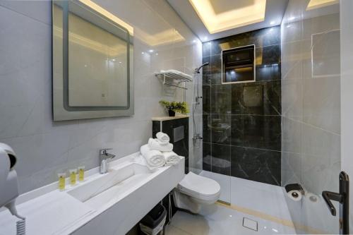 亚喀巴Three Palms Suites的一间带水槽、卫生间和淋浴的浴室
