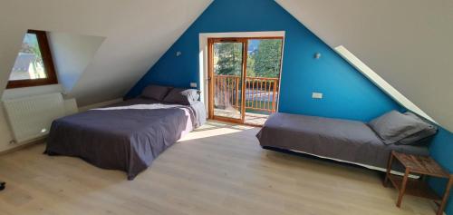 巴涅尔-德吕雄Maison de la Lionne的蓝色墙壁客房的两张床
