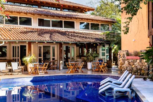 坎布里Pousada Camburizinho的一个带游泳池、桌椅的度假酒店