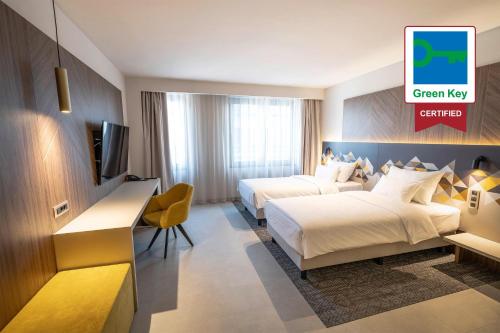 卢布尔雅那奥地利卢布尔雅那潮流酒店的一间酒店客房,设有两张床和电视