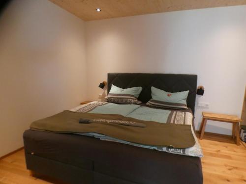 上施陶芬Stylische Fewo in Bestlage in neugebautem Holzhaus mit Oberstaufen Plus的一张床上,上面有黑色床头板