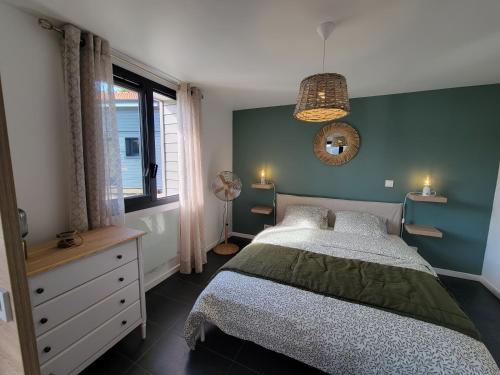 安德诺莱斯贝恩Les Cabanes de l'Airial Ecume的一间卧室设有一张床和绿色的墙壁