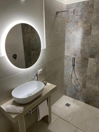 塔兰托Palazzo Matà Boutique Hotel的浴室配有盥洗盆和带镜子的淋浴